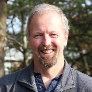 Headshot portrait of digital marketing executive and SEO author Eric Enge smiling outdoors with a goatee and gray zip-up fleece jacket.