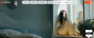 Screenshot of the Fireart Studio homepage showing top navigation pill buttons, an orange Contact button, a Dribbble Select badge, and a woman sitting on a sunny windowsill looking at her smartphone.
