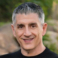 Headshot portrait of SEO expert and agency founder Jason Hennessey smiling in a black shirt outdoors.
