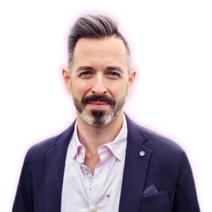 Headshot portrait of tech entrepreneur and SEO expert Rand Fishkin wearing a navy blazer, striped shirt, and pocket square with a soft glowing outline.